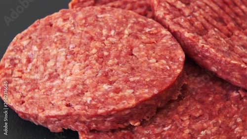 Raw patties made from ground beef lie on a table