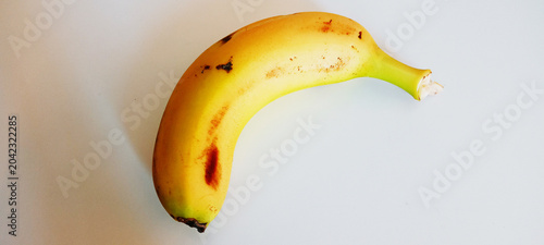 Isolation of fresh, ripe banana fruit showing peel texture and spots.