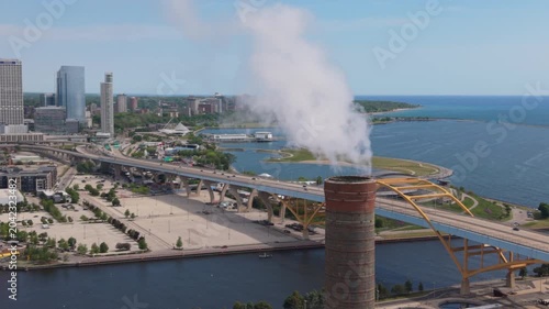 tighter flying counter clockwise around smokestack revealing downtown Milwaukee