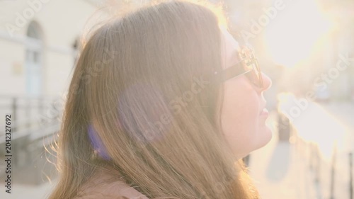 Young woman walking in European city street at sunrise