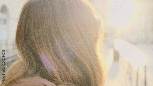 Young woman walking in European city street at sunrise