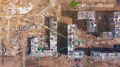 Construction progress of urban residential development with tower cranes and machinery in an active construction zone