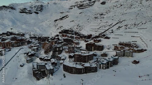 Aerial drone video Val Thorens resort village overview snow buildings avalanche barriers winter French Alps 4K