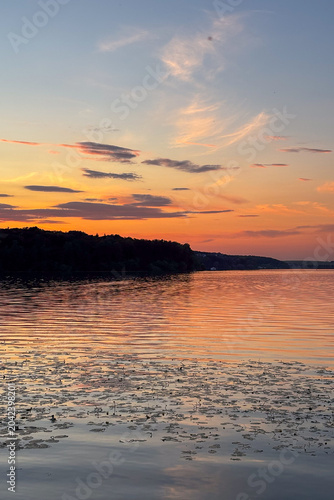 A peaceful walk on sunset unfolds along the Ternopil Pond in Ternopil, Ukraine, where calm waters and lush surroundings create a serene urban retreat.
