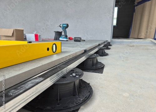 Foto Floor level view of an access raised floor installation with adjustable pedestals and hand tools