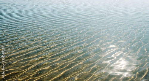 Minimalist water surface ripple texture with natural sunlight reflection in serene aquatic setting