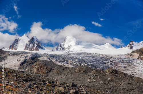 a glacier against the backdrop of snow-capped mountain peaks