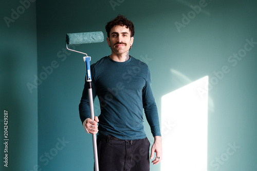 Bild auf Leinwand Man painting new apartment wall with paint roller