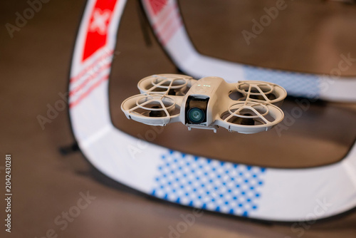 Photography Close up of lightweight palm sized quadcopter with propeller guards flying insid