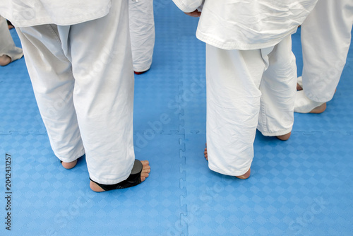 Konstfotografi Low section rear view of young karate students in white judo gi pants standing b