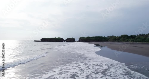 Bali landscape drone footage captures ocean waves, beaches, and rocky coastline in a tropical setting during daytime hours