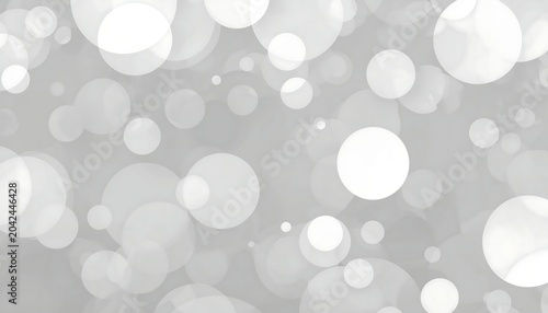 A soft gray background is artfully decorated with a scattering of translucent white bokeh circles of various sizes and opacities.