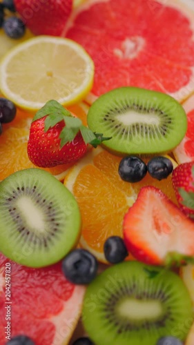 Background of fresh fruits and berries rotating. Vegan sweet food, flat lay.