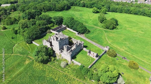 Majestic panoramic view of ancient medieval castle ruins in Scotland with stone battlements and historic fortifications. Scenic architecture of an old fortress surrounded by green countryside under a 