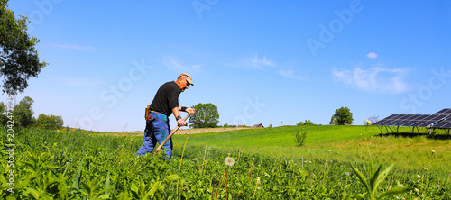 Photos A farmer mows grass with a hand scythe, foraging in the countryside