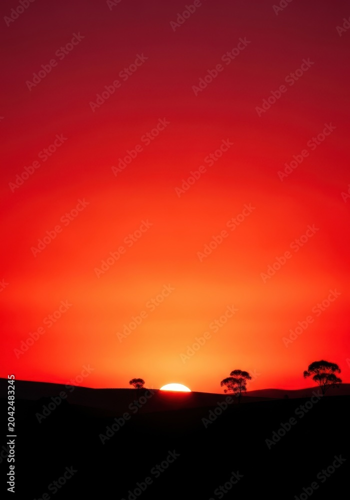 Fototapeta premium Intense red and orange hues paint the dramatic morning sky above the silhouette of the peaceful landscape at dawn, breaking light, peaceful, atmosphere