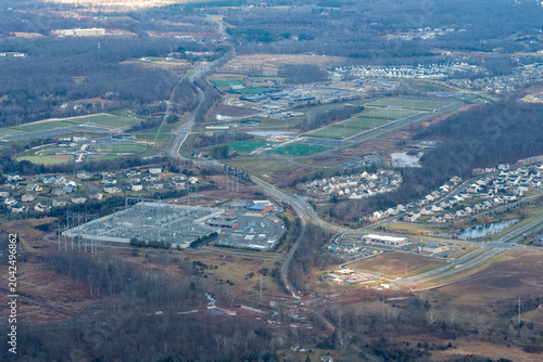 Aerial view of Northern Virginia showing high school athletic complex with baseball diamonds and football field, and an electrical substation serving the Dulles data center corridor.
