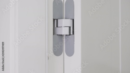 Concealed door hinge mechanism providing minimalist interior design