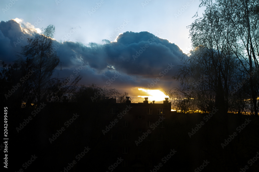 Obraz premium Dramatic sunset over a residential building silhouette