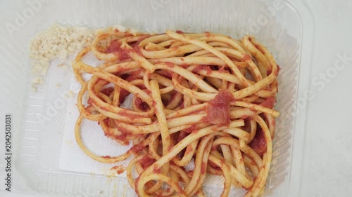 Bucatini pasta with tomato sauce in container