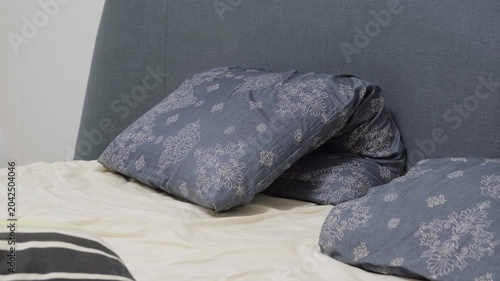 Bed with patterned blue pillows and headboard