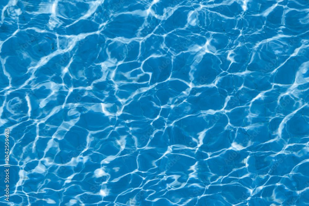 Obraz premium Abstract blue swimming pool water surface with sunlight reflections and ripple pattern background