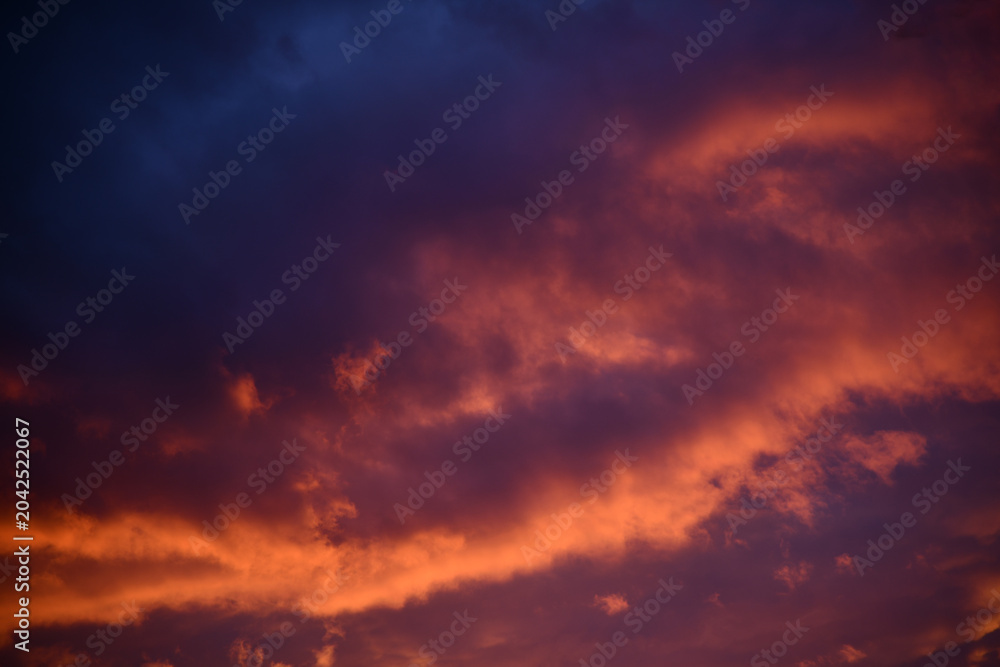 Fototapeta premium Remote view of helicopter silhouette on background of vivid sundown sky over city in evening