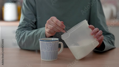 Woman using a spoon adding too much sugar to drink tea or coffee in cup, closeup. Addiction, unhealthy nutrition, diet concerns and diabetes problems, insulin spike