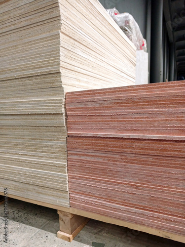 Magnesite sheet boards stacked in rows in hardware supermarket with construction material display and repair supply products