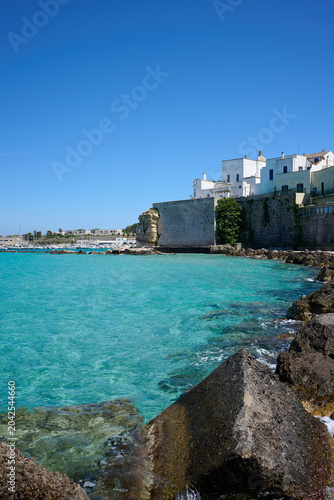 erosion protection concrete blocks and coastal buildings in Otranto Italy with turquoise sea and blue sky
