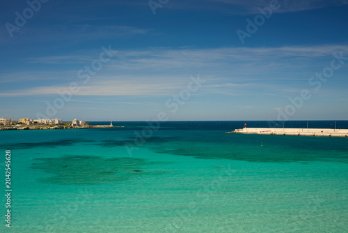 Harbour  harbor in Puglia southern italy with single yacht turquoise sea and blue sky in summer