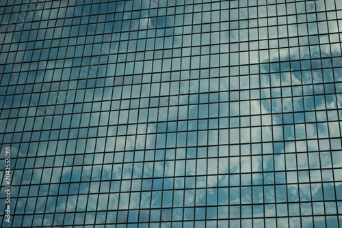 Fotografie Abstract Glass Facade Reflecting Clouds on Błękitny Wieżowiec Blue Tower in Wars