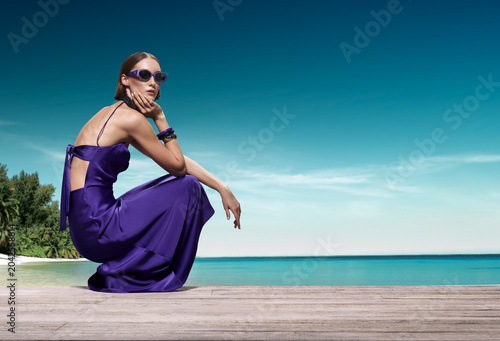 Obraz na plátne Exquisite high fashion portrait of Caucasian model crouching gracefully on woode