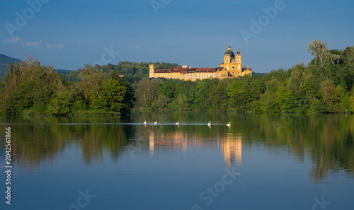 Photography Scenic view of historic Melk Abbey in Austria with swans parading on water at su