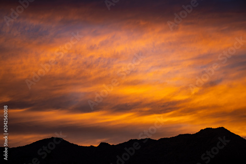 fiery orange sunset over desert mountains