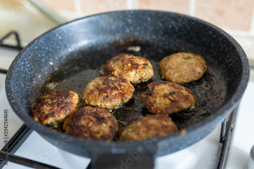 Tableau sur toile Close-up of savory beef meatballs frying in a sizzling hot skillet