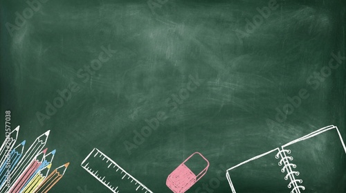 A green chalkboard with drawing of stationery and notebook, used for teaching and learning