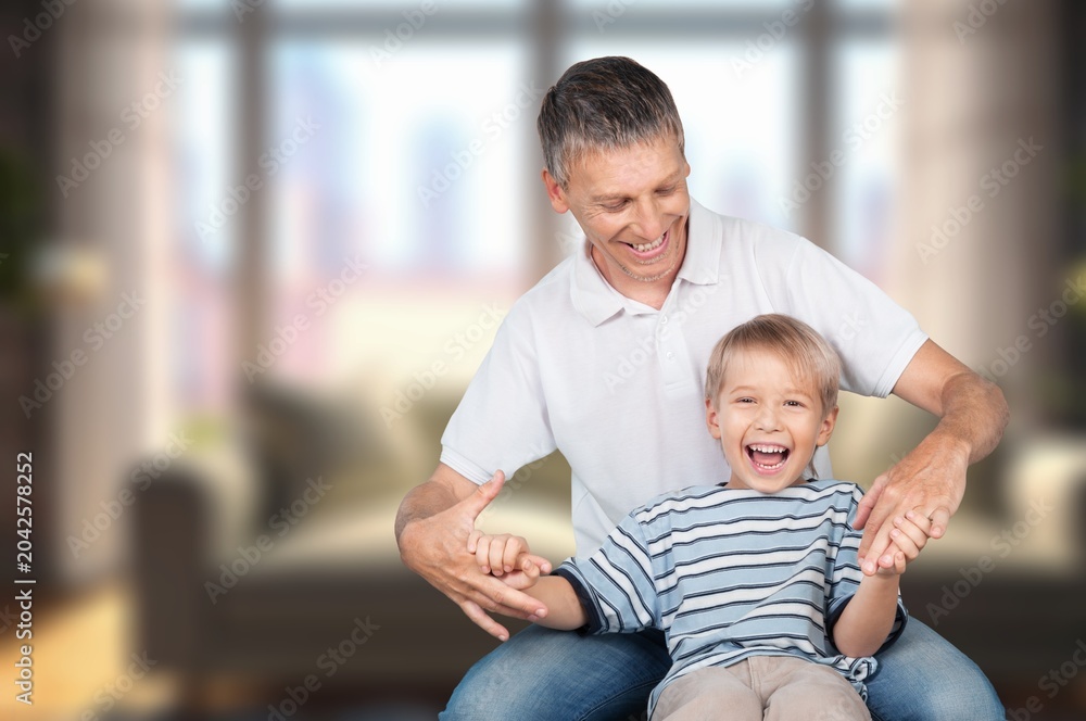 Obraz premium Cheerful father and son at home, have fun together
