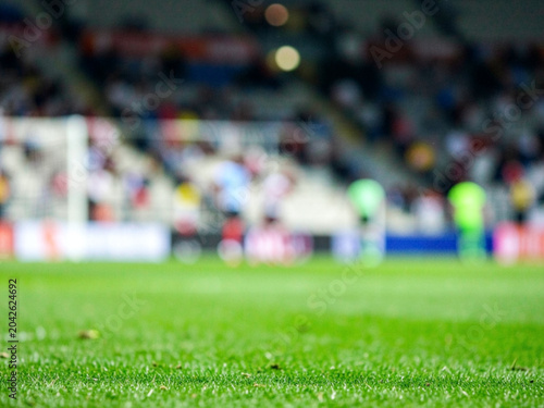 A blurry view of a soccer field with players and spectators in the stands