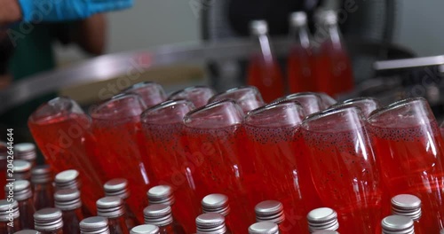 At beverage bottles line, focused workers systematically organizes the bottles into a large container. then staged at the loading dock, ready for distribution in beverage drinking water factory