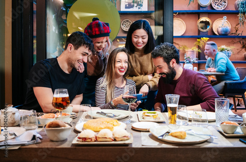 Diverse friends laughing and sharing a memorable dinner