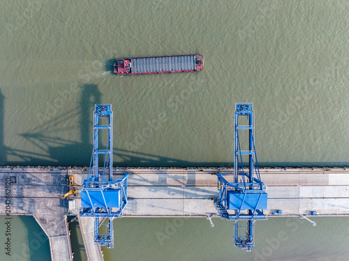 Overhead aerial view of port cranes and barge