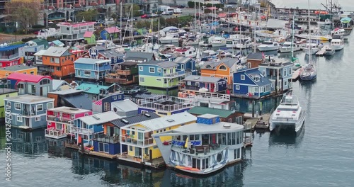 Aerial view of colorful floating houses under a cloudy sky in Victoria Harbour, Canada