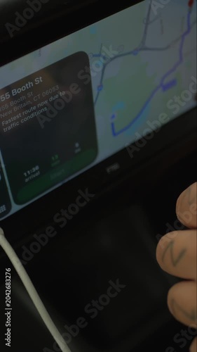 Close-up of a finger tapping a car navigation touchscreen with map route, representing travel planning, directions, traffic, and modern driving.