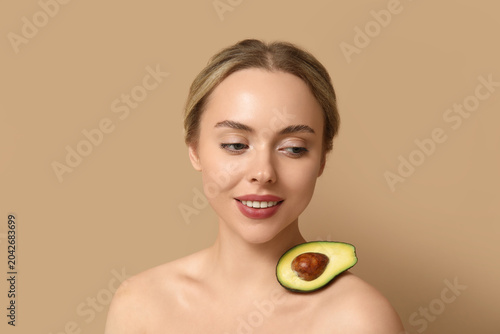 Young woman with avocado on...
