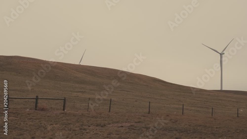 Wind turbines generating renewable energy on rolling hills