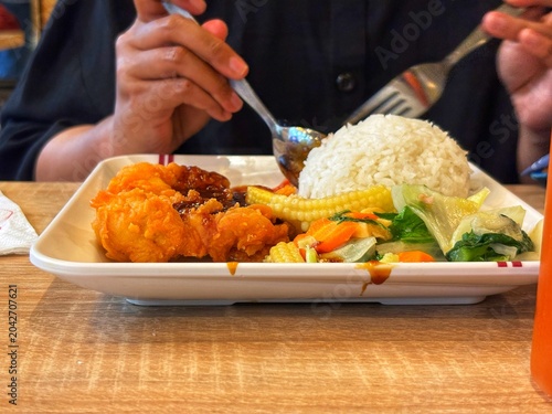 A perfect comfort meal of crispy fried chicken, steamed rice, and stir-fried vegetables