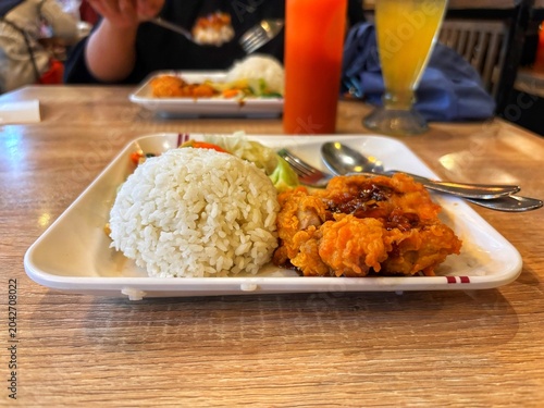 Enjoy a plate of crispy and savory fried chicken with rice. Truly appetizing!
