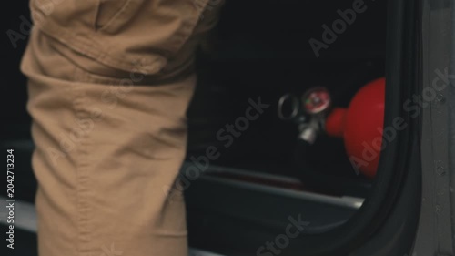 Worker with fire extinguisher opening truck door