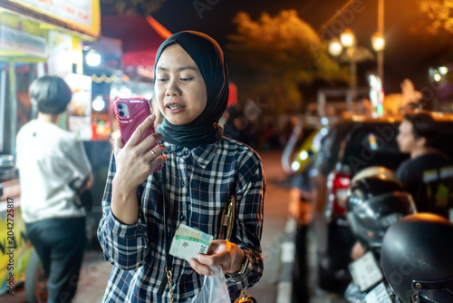 Indonesian Woman Using Smartphone at Yogyakarta Night Market